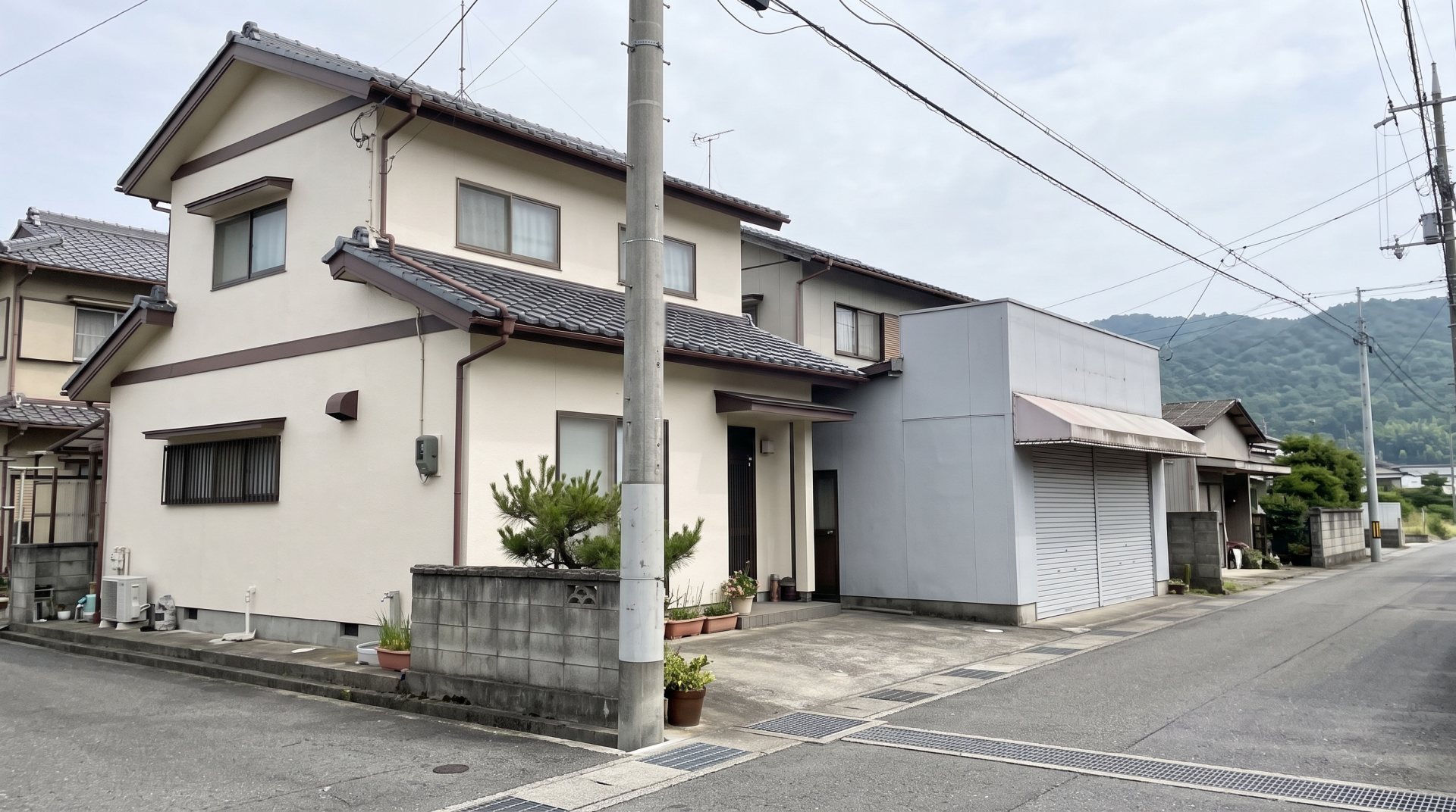 曇りの日の住宅地で、塗り替えを終えた家と、となりの小さな店舗(イメージ)